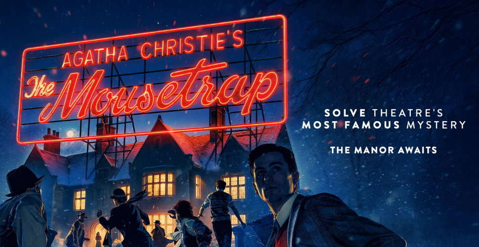 Modern glass-fronted building with large windows reflecting a blue sky and surrounding greenery